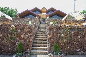 a stone wall with a staircase in front of a building at EKA Resort in Goris