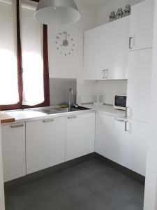 a white kitchen with white cabinets and a clock on the wall at Cà Marta in Venice