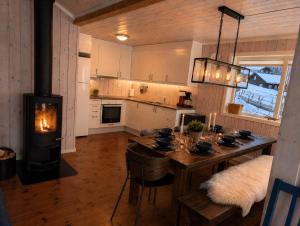 a kitchen with a table and a wood stove at Håvi Solsiden 11C in Trysil