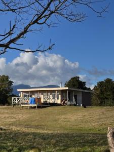 a house on the side of a field at Cabaña con tinaja en La Poza Hualaihué in Gualaihue