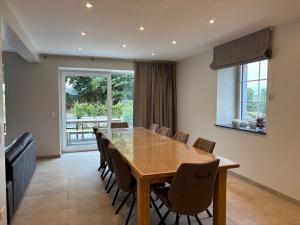 a dining room with a wooden table and chairs at La Petite Reine in Bertrix