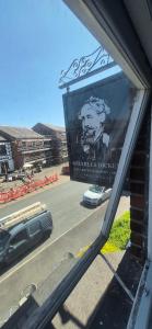 a reflection of a sign in the window of a building at The Charles Dickens in Wigan