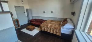 a bedroom with a bed and a couch at The Charles Dickens in Wigan