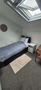 a bedroom with a bed and a clock on the ceiling at The Charles Dickens in Wigan