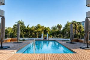 a swimming pool with umbrellas on a wooden deck at On Park 516 At Century City in Cape Town