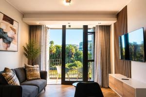 a living room with a couch and a tv at On Park 516 At Century City in Cape Town