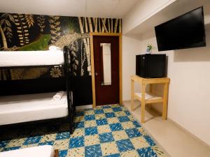 a room with two bunk beds and a flat screen tv at Casa Dolce Vita in Puerto Viejo