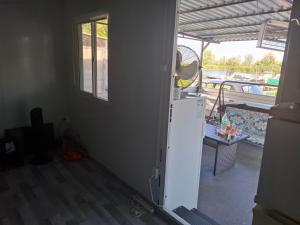a kitchen with a refrigerator and a view of a boat at Cuki Apartmanház in Sarud +4 photos