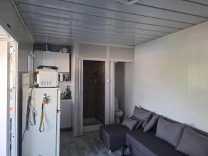 a living room with a couch and a refrigerator at Cuki Apartmanház in Sarud