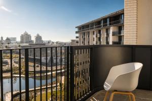 a white chair sitting on a balcony with a view at On Park 516 At Century City in Cape Town