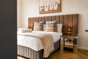 a bedroom with a large bed with a wooden headboard at On Park 516 At Century City in Cape Town