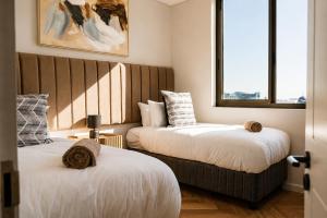 two beds in a room with two windows at On Park 516 At Century City in Cape Town +63 photos