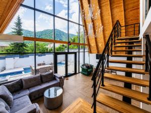 a living room with a couch and a staircase at ES Dream A-Frame Cabin in Gabala