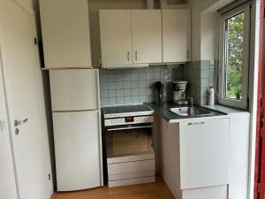 a kitchen with a white refrigerator and a sink at Mølhøjvej lejlighed in Andrup