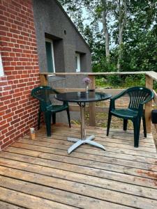 a table and two chairs on a wooden deck at Mølhøjvej lejlighed in Andrup