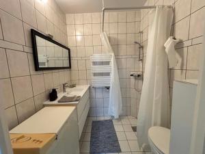 a white bathroom with a sink and a shower at Mølhøjvej lejlighed in Andrup