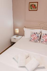 a white bedroom with a white bed with a lamp at Corfu Glyfada Beach Apartments 67 in Glyfada