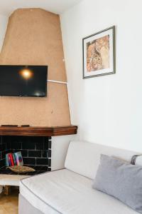 a living room with a couch and a flat screen tv at Corfu Glyfada Beach Apartments 67 in Glyfada +44 photos