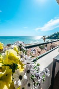 a bouquet of flowers sitting on a balcony overlooking the ocean at Corfu Glyfada Beach Apartments 67 in Glyfada