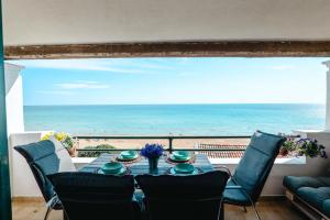 a table with chairs and a view of the ocean at Corfu Glyfada Beach Apartments 67 in Glyfada