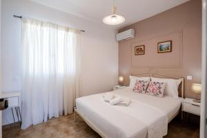 a bedroom with a white bed with two pillows at Corfu Glyfada Beach Apartments 67 in Glyfada