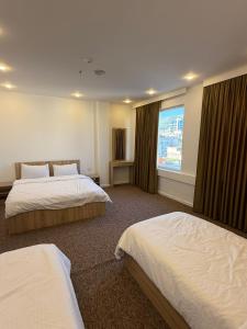 a hotel room with two beds and a window at Hotel Mihad sulaymaniyah in As Sulaymānīyah +8 photos