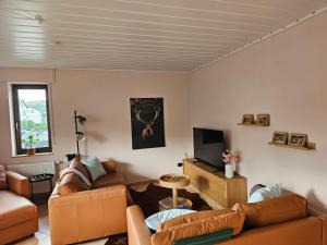 a living room with two couches and a television at WOLL Forest in Schmallenberg