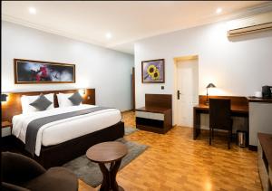 a hotel room with a bed and a desk at Kaslon Hotel, Garki 2 Abuja in Abuja +5 photos