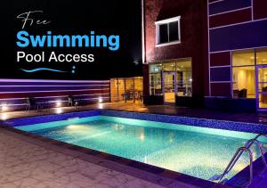 a swimming pool in front of a building at Kaslon Hotel, Garki 2 Abuja in Abuja