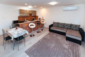a living room with a couch and a table at Déjá-Vu Apartmanház in Szigetvár
