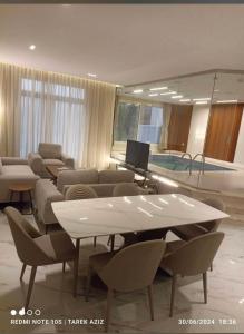 a living room with a table and chairs and a television at استراحات وفلل رفايا in Abha