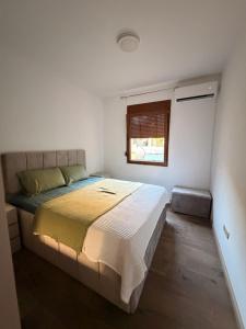 a bedroom with a large bed with a window at Iva Apartment in Kumbor