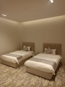 two beds sitting next to each other in a room at استراحات وفلل رفايا in Abha +27 photos