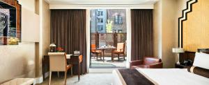a hotel room with a bed and a view of a patio at Walker Hotel Greenwich Village in New York