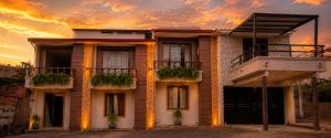 a building with a sunset in the background at Florida Palace Hostal in Samaipata