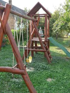 a wooden swing set in a yard at Handó Porta in Szenna
