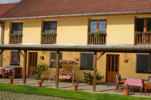 a house with a porch with chairs and tables at Handó Porta in Szenna