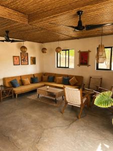 a living room with a couch and a table at Tipsy Gypsy Bar & Hotel in Tola