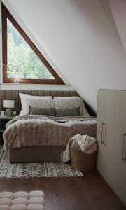 a bedroom with a large bed with a window at Zacisze pod Tatrami in Suche