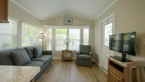 a living room with a couch and a flat screen tv at Road Runner Travel Resort in Fort Pierce