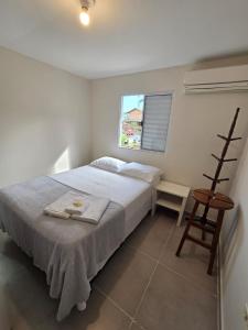 a bedroom with a bed and a chair and a window at Pousada Casa Meraki in São Sebastião