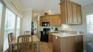a kitchen with wooden cabinets and a table and a counter at Road Runner Travel Resort in Fort Pierce