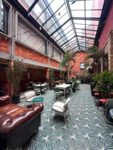 a lobby with a leather couch and tables and chairs at Hotel Oliver in Bogotá