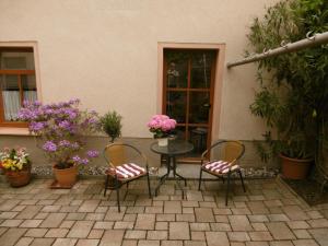 un patio con tavolo, sedie e fiori di Ferienwohnung Christine Nestler a Annaberg-Buchholz