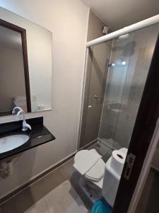 a bathroom with a shower and a toilet and a sink at Pousada Casa Meraki in São Sebastião