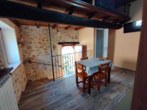 a table and chairs in a room with a stone wall at Casa vacanza da GIGI in Calascio