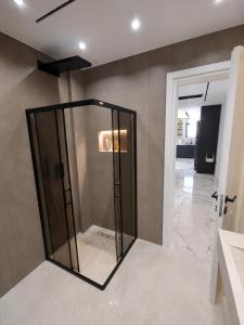 a bathroom with a glass shower in a room at IDeal Sea View Apartment in Vlorë +18 photos