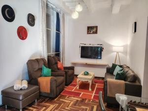 a living room with two couches and a flat screen tv at KANTIQ House in Cusco