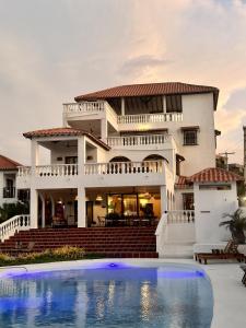 a house with a swimming pool in front of it at Hotel Villa Toti in Santa Verónica