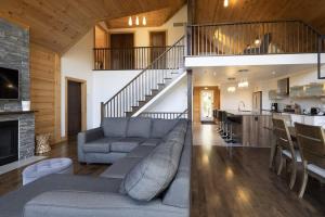 a living room with a gray couch and a kitchen at Chinook 172 in Sainte-Marguerite